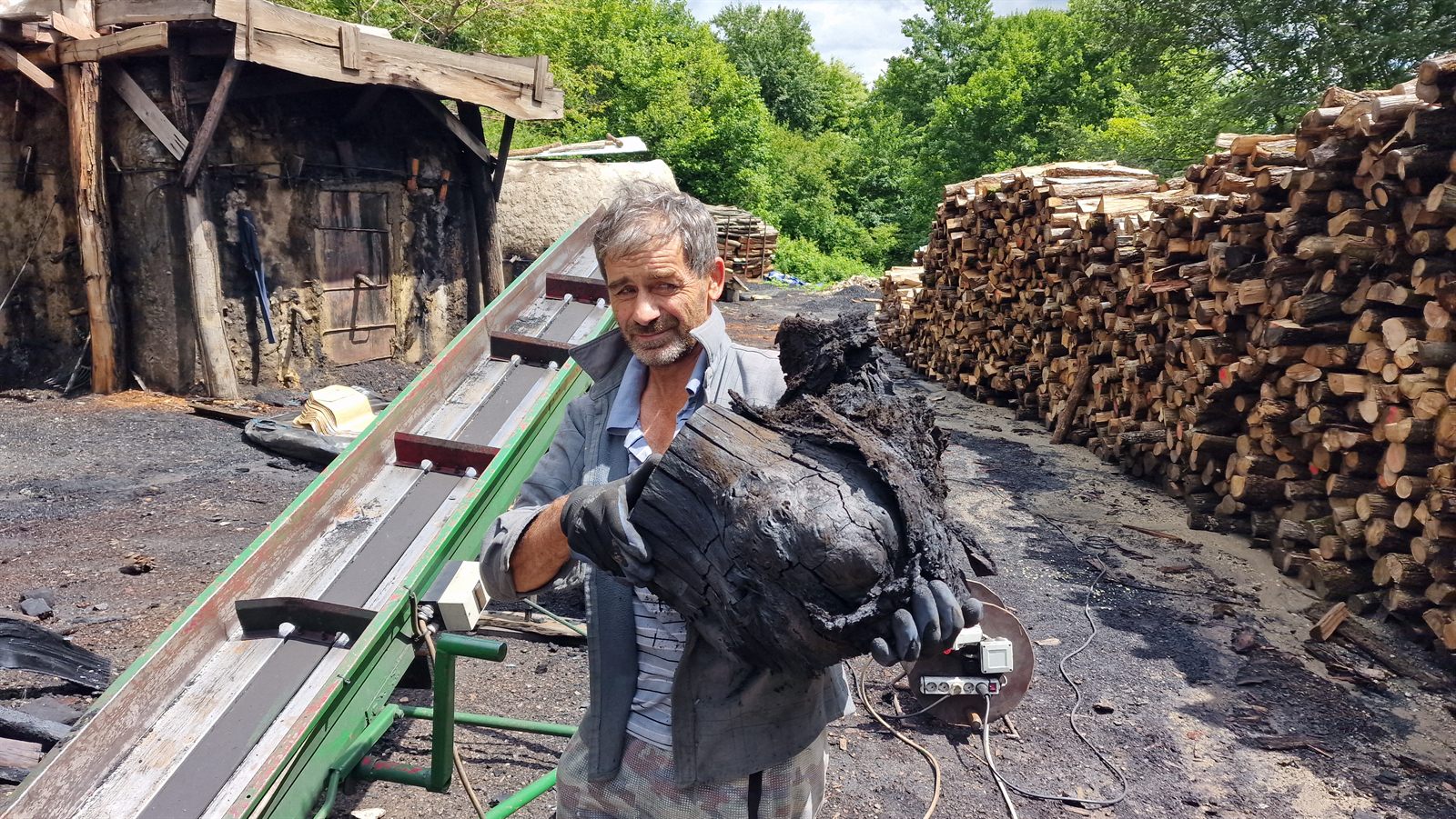 Radnik pokazuje veliki komad gotovog drvenog ugljena